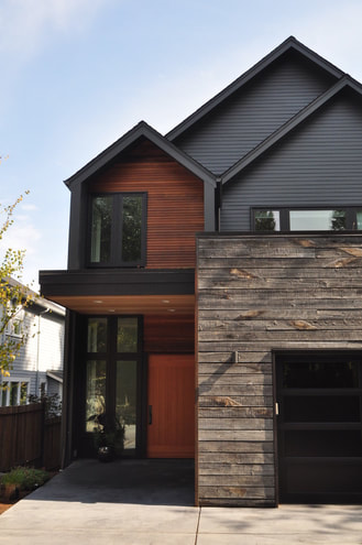 This is a picture of a mixed material siding project using Iron gray horizontal plank, custom hardwood and rustic reclaimed wood to give a contemporary look